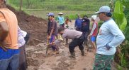Warga setempat bersama personil BPBD, TNI Polri Satpol PP dan relawan membersihkan longsoran tanah yang menutup akses jalan desa. (Foto: Humas/beritamagelang)