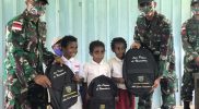 Prajurit Yonmek 403/WP bagikan tas kepada anak-anak di perbatasan RI-PNG. (Foto: Penerangan Yonmek 403/WP) “