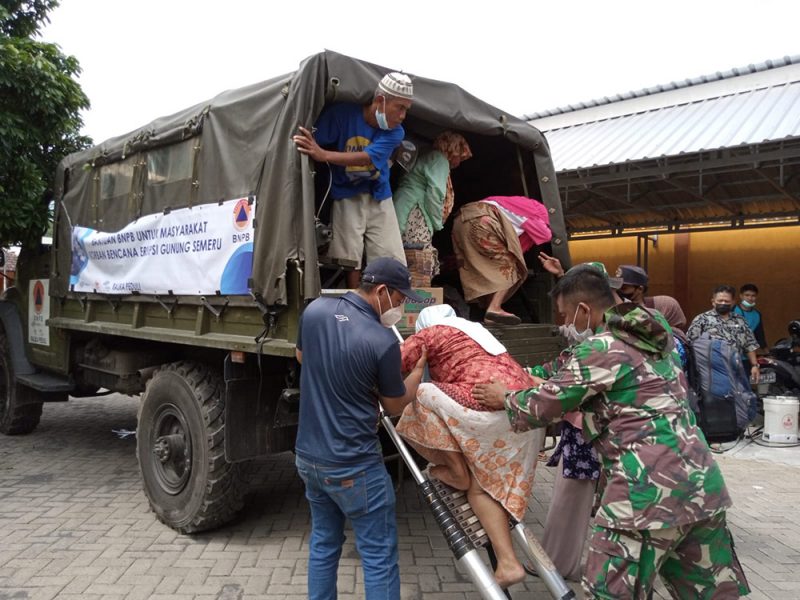 Personil TNI dan relawan dengan sabar membantu masyarakat lanjut usia (lansia) yang berada di posko pengungsian untuk mengikuti proses pemindahan ke lokasi yang telah disediakan, Jumat (10/12/2021).  (Foto: MC Kab. Lumajang/Pendim 0821)