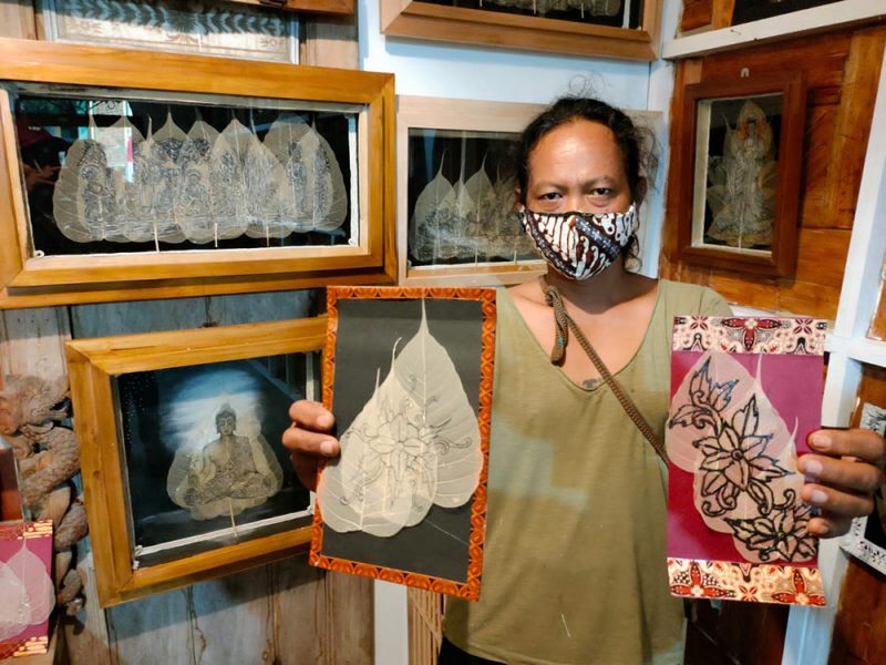 Budiyono menunjukan lukisan daun Bodhi yang telah dipisahkan pigmennya, sehingga menjadi media lukis yang eksotis. (Foto: humas/beritamagelang)