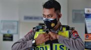 Seorang anggota Polisi di Surabaya sedang memakai bodycam. (Foto:selalu.id)