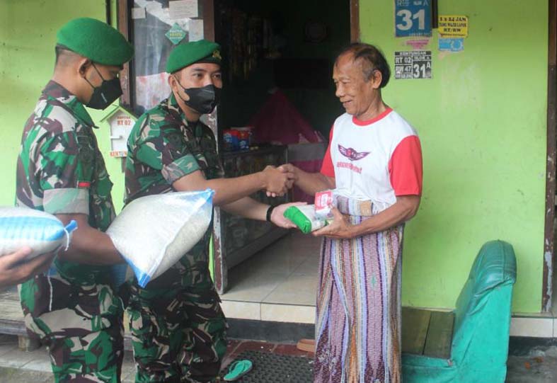 Prajurit Yonif Mekanis 403/WP memberikan bantuan paket sembako kepada warga di sekitar kesatrian.  (Foto: istimewa)