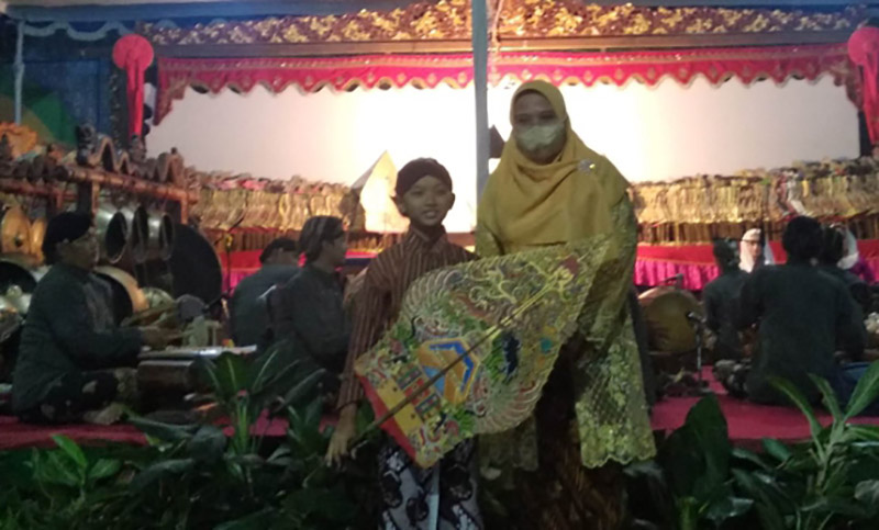 Kepala Sekolah SD Muhammadiyah Condongcatur, Sulasmi SPd secara simbolis menyerahkan wayang menandai pertunjukan wayang kulit. Foto: Ist 