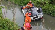 Petugas mengevakuasi Honda Brio yang tercebur ke sungai di Surabaya. Foto: selalu.id