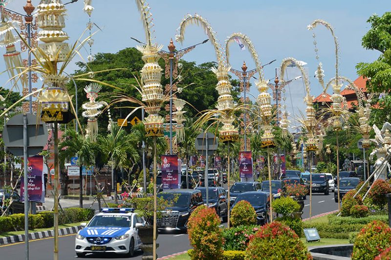 Kendaraan melintas di jalan yang pinggirnya dihiasi penjor atau hiasan janur kuning khas Bali di Jalan Bandara Ngurah Rai, Kabupaten Badung, Bali, Kamis (10/11/2022). Pemerintah memasang penjor, bendera negara peserta, baliho, dan spanduk di sejumlah jalan protokol di Bali untuk memeriahkan KTT G20 yang akan berlangsung pada 15-16 November 2022. ANTARA FOTO/Aditya Pradana Putra/nym.