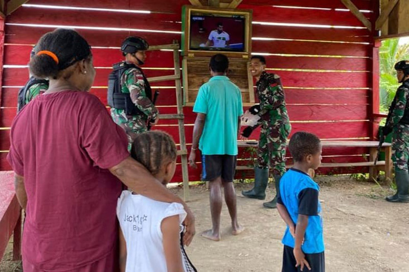 Satgas Yonif 143/TWEJ tengah memperbaiki sarana hiburan warga berupa pesawat televisi yang telah lama rusak di Pos Siskamling Kampung Yuruf, Distrik Yaffi, Kab. Keerom, Papua, Minggu (7/5/2023). Foto: Satgas Yonif 143/TWEJ