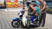 Babinsa Serda Heri Kuwatno dengan suka rela membantu warga yang kerepotan membawa pulang beras bantuan. (Foto: Pendim 0707)